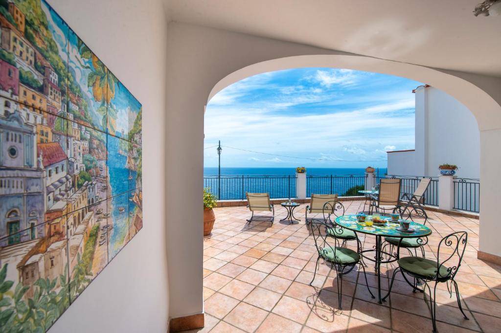 a patio with a table and chairs and the ocean at Casa Marina in Praiano