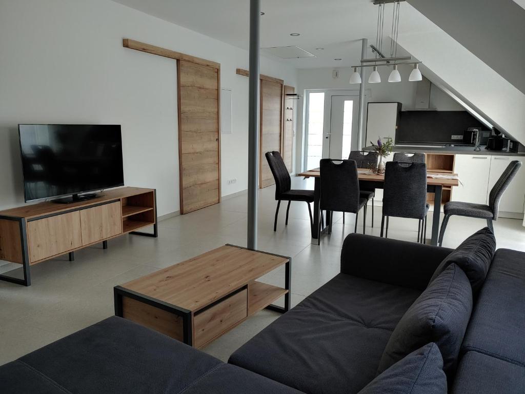 a living room with a couch and a tv and a table at Ferienwohnung Hagebutte in Bad Bocklet