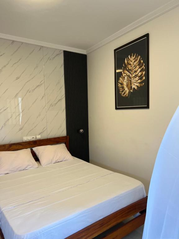 a bedroom with a bed and a picture on the wall at Maison Sika in Zogbégan