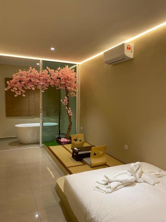a bedroom with a bed and a tree with pink flowers at Ipoh Town Hotel by Serenity in Ipoh