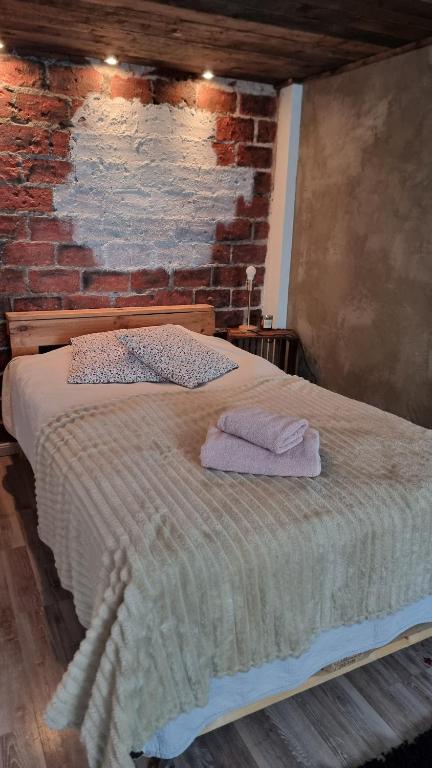 a bed in a room with a brick wall at Cozy Studio in Kouvola