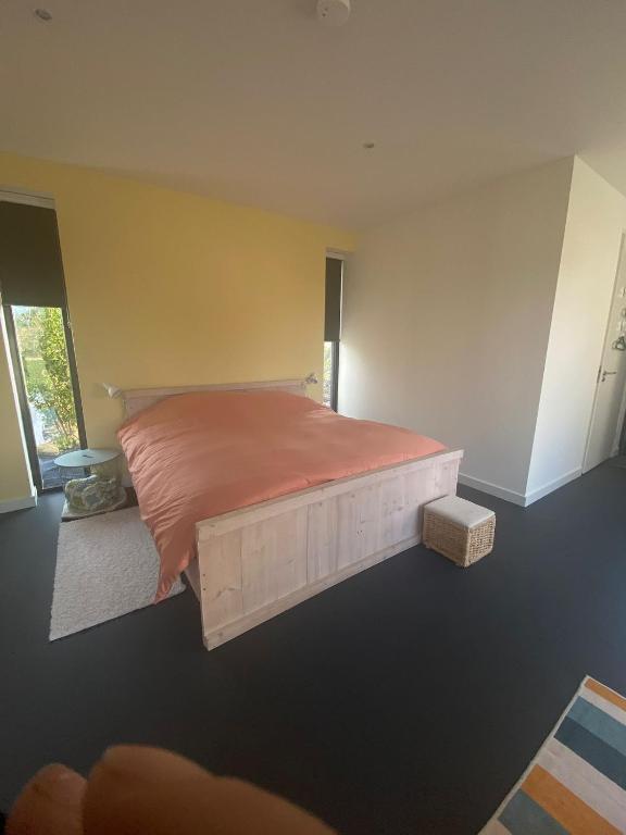 a bedroom with a bed with an orange comforter at Het Hunebedje in Vries