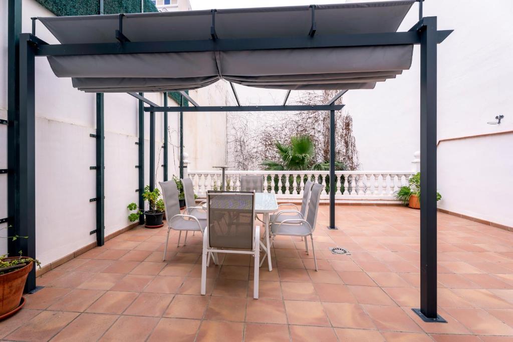 a patio with a table and chairs under a canopy at Casa sol in Vélez-Málaga