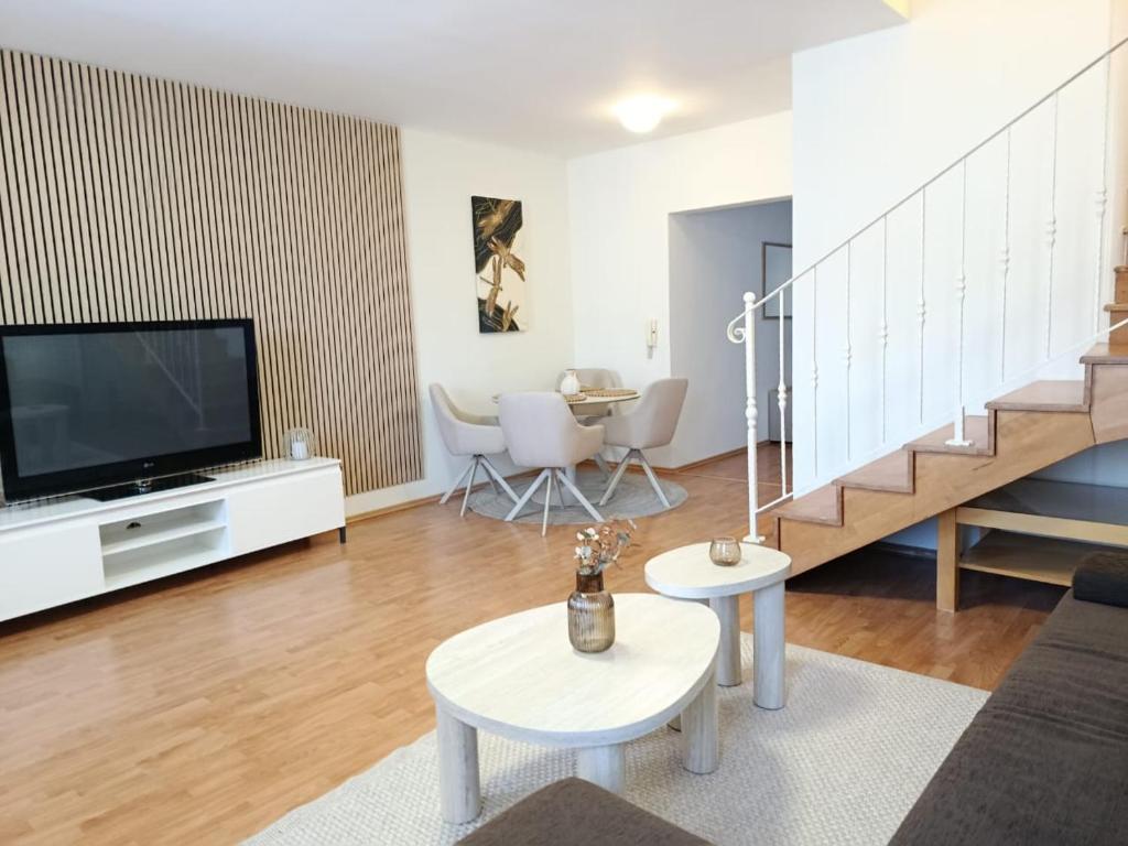 a living room with a flat screen tv and a staircase at Central apartment in Staré Mesto