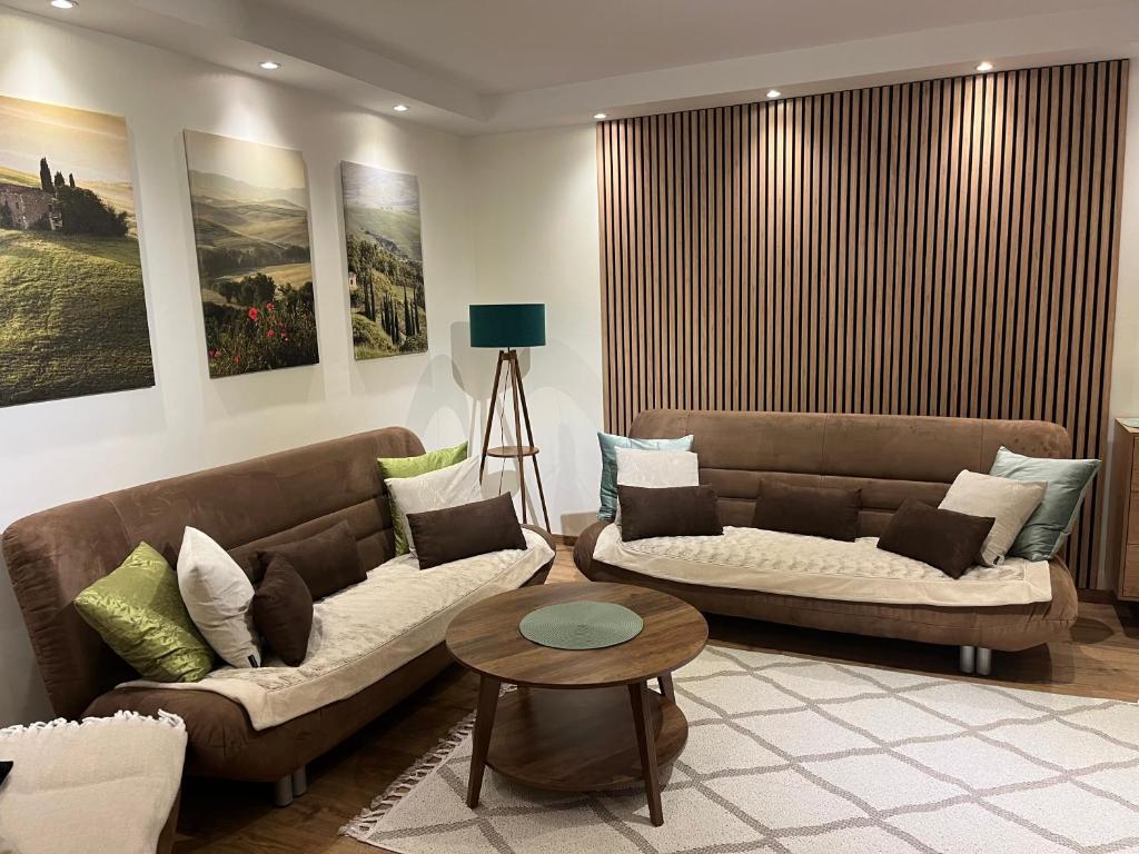 a living room with two couches and a table at Apartament Emilia in Koszalin