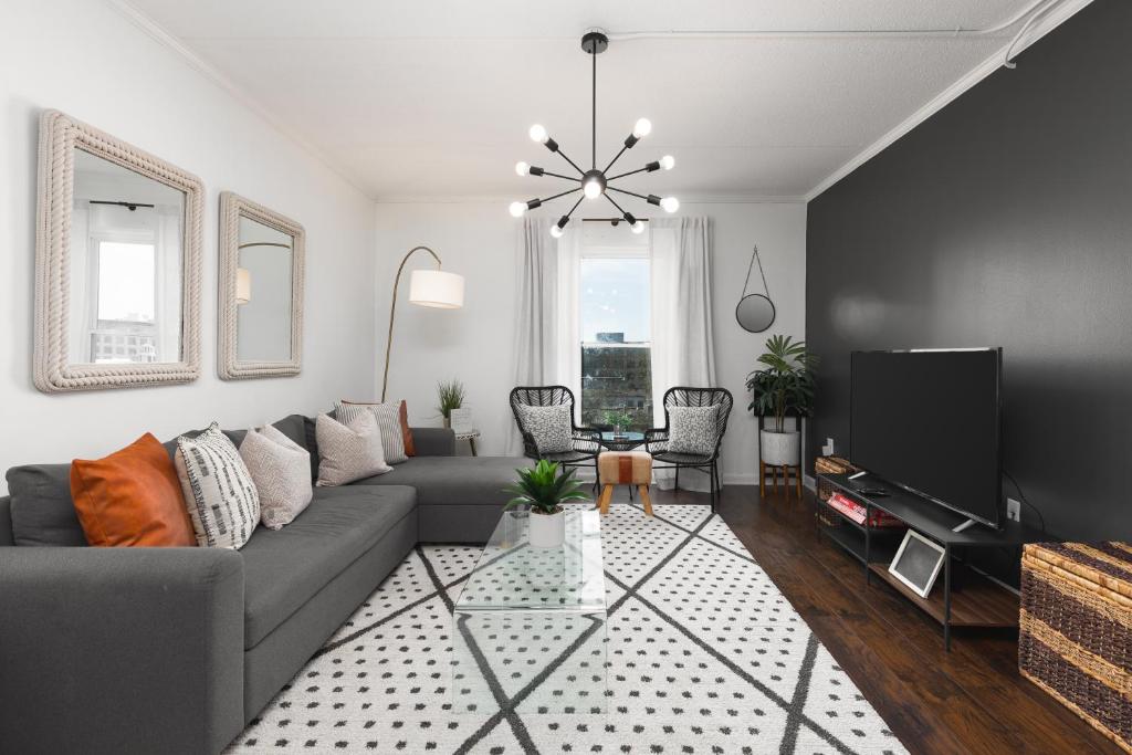 a living room with a couch and a tv at Home to the Stars on Music Row with Pool and Free Parking in Nashville