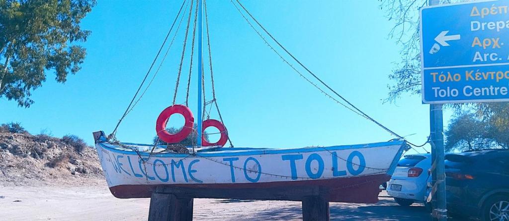 a boat hanging from a sign in a parking lot at sunwave Tolo in Tolo