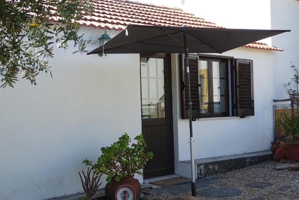 a black umbrella in front of a house at Casa de Campo em Taipa in Coruche