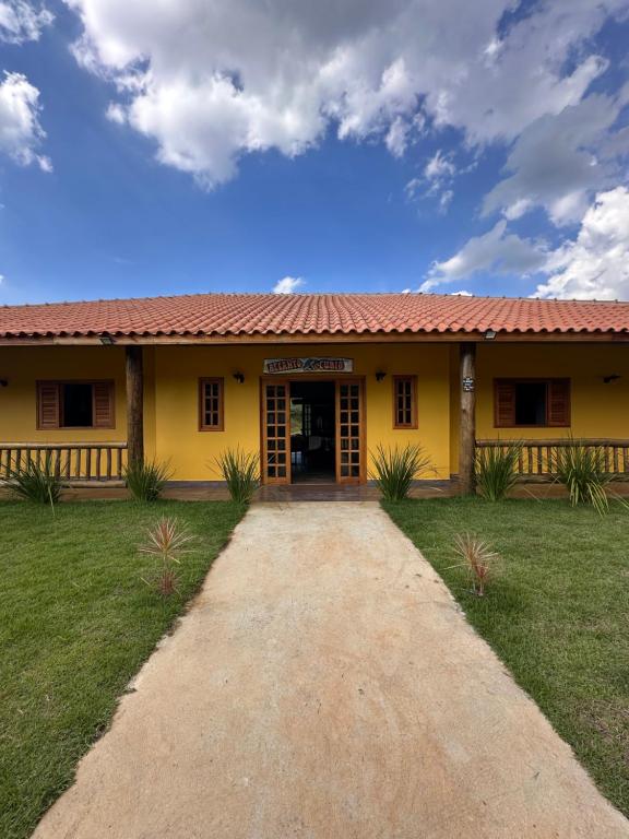 a yellow building with a driveway in front of it at Recanto do curio in Aparecida