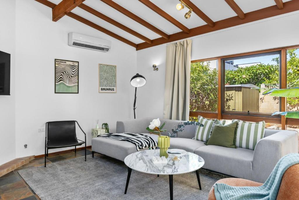 a living room with a couch and a table at North Perth 3BR Home Steps To Hyde Park & Dining in Perth