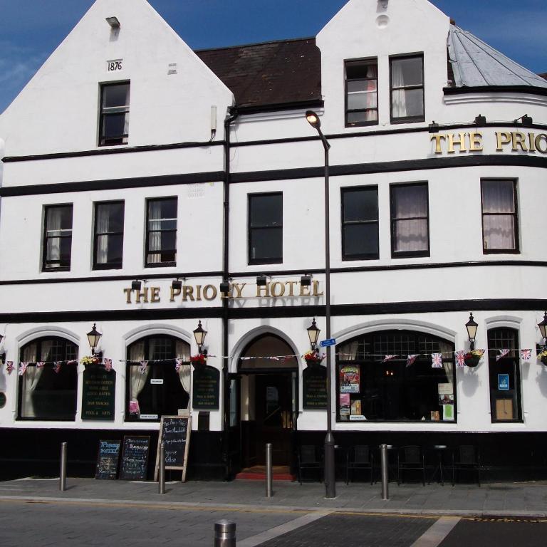 a white building on the corner of a street at Dover Priory Hotel in Dover