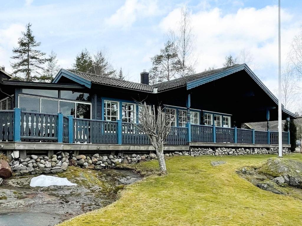 a large blue house with a large deck at 4 person holiday home in SÖDERKÖPING in Söderköping