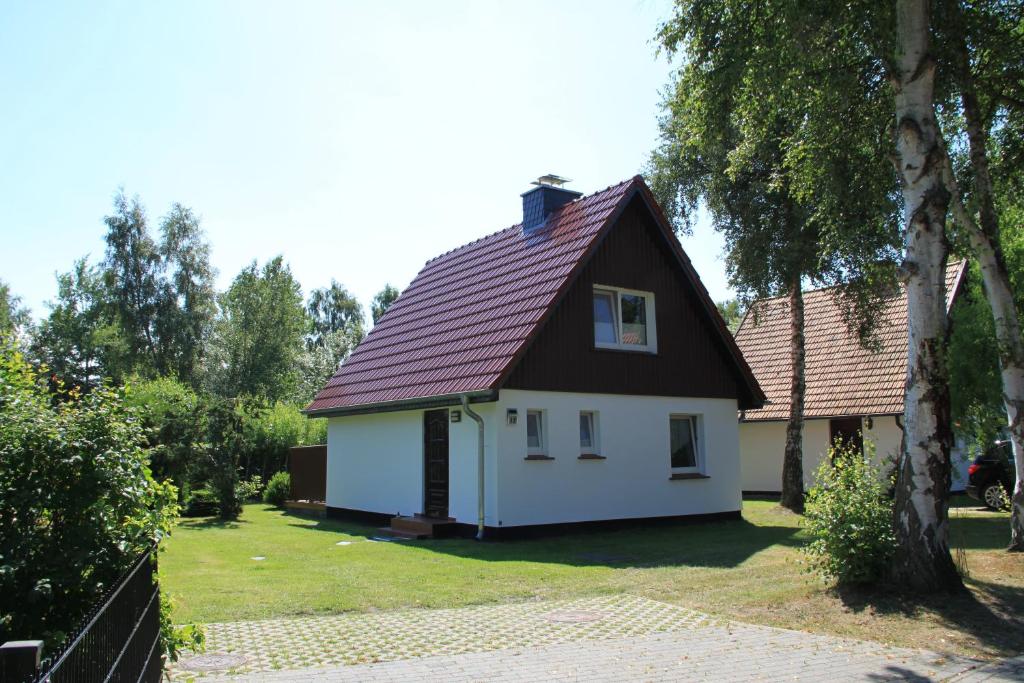 a small white house with a red roof at Haus Ostseewind in Zingst
