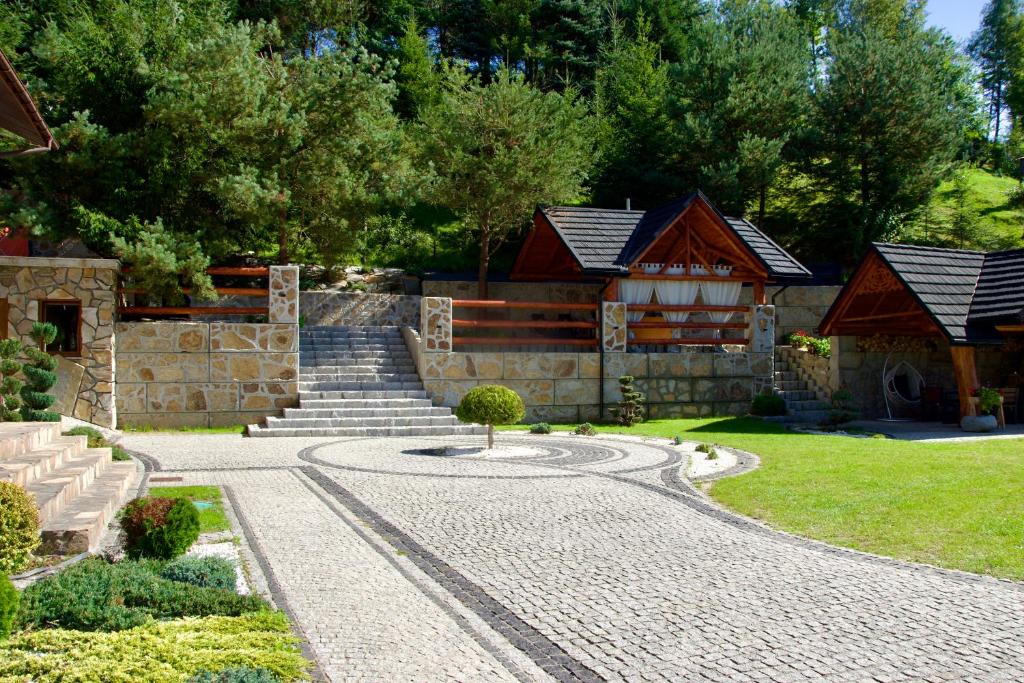 a house with a stone path in front of a house at Dolina Popradu Apartments in Muszyna