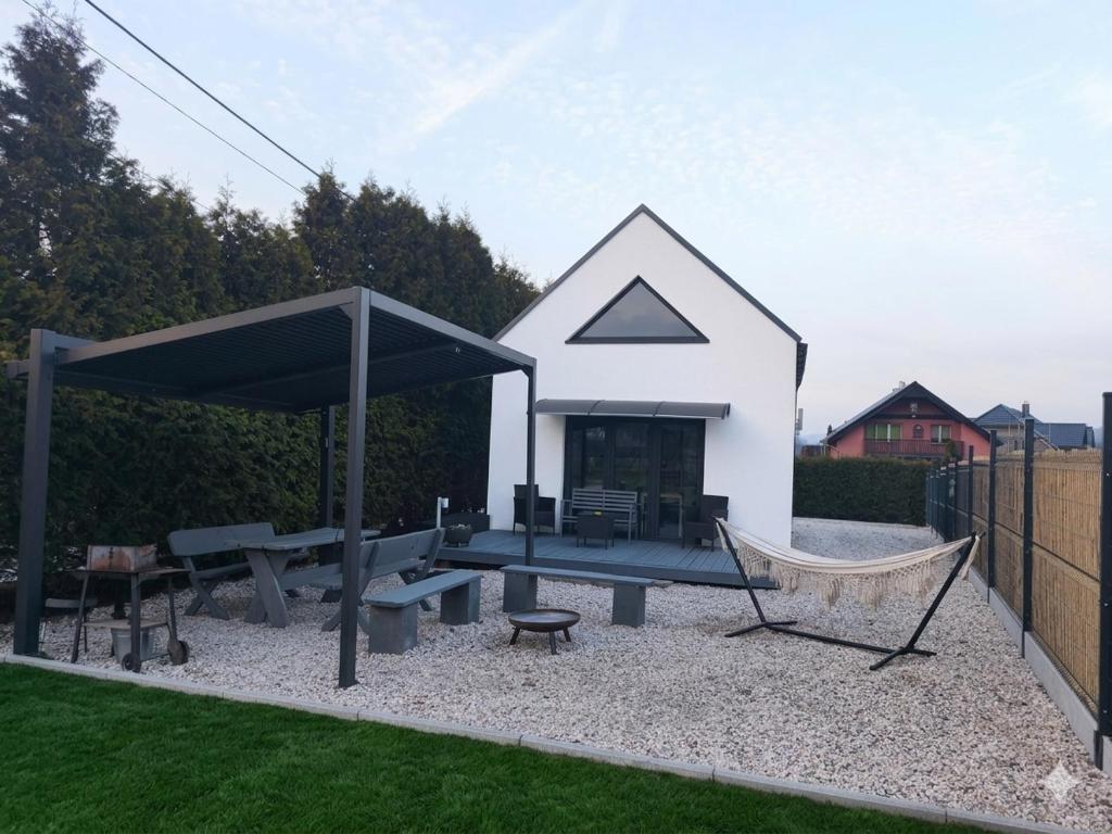 a backyard with a ping pong table and a hammock at Ekologiczny domek "Ciszyca" z widokiem na Śnieżkę in Kostrzyca