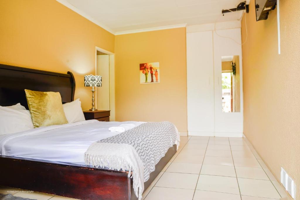 a bedroom with a bed and a yellow wall at Cozy guestrooms in Midrand in Midrand