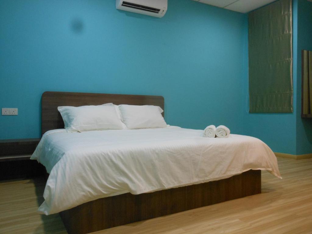 a blue bedroom with a bed with towels on it at Eiman Homestay, Kluang in Kluang