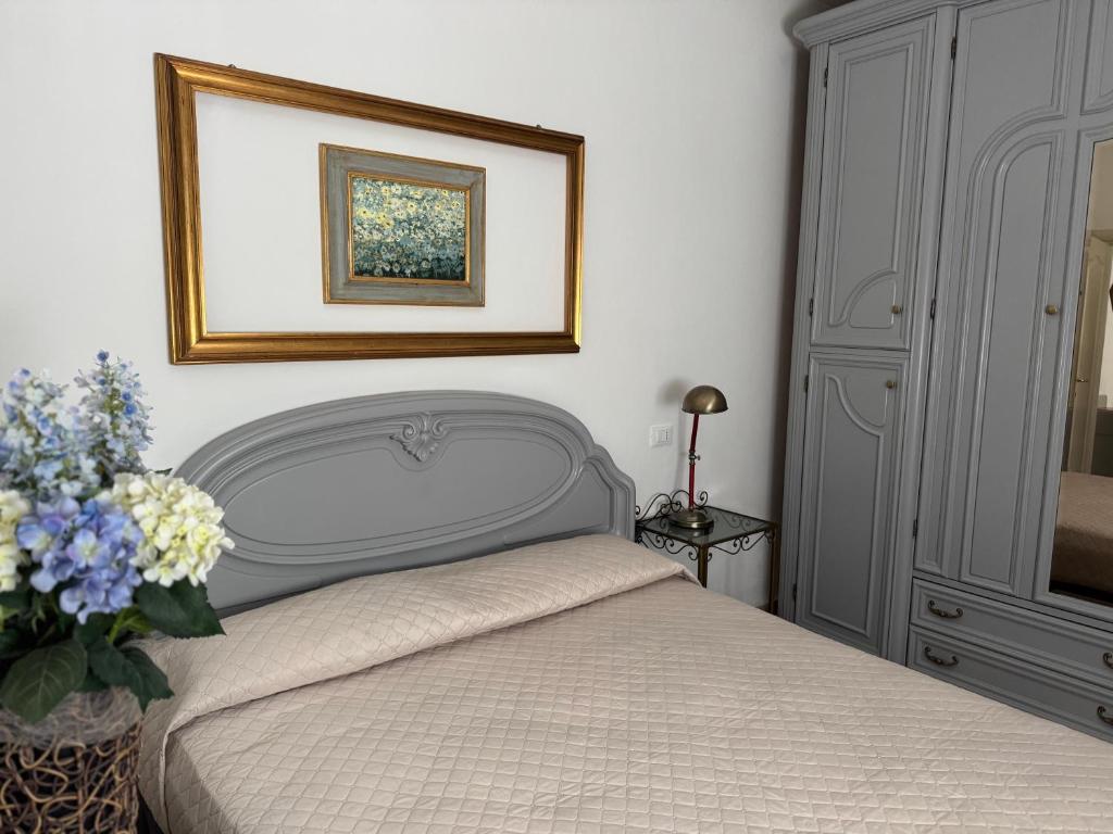 a bedroom with a bed and a picture on the wall at Le Due Sorelle in Savio di Ravenna