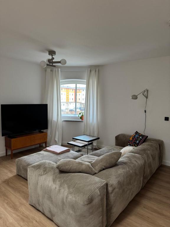 a living room with a couch and a flat screen tv at Zum alten Pasewalker Kaufmann in Pasewalk