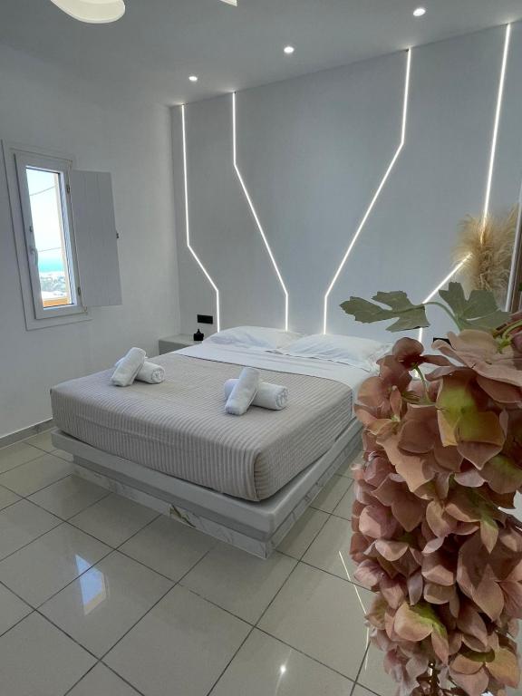 a bedroom with a bed with two towels on it at Fira centerline Prestige suites in Fira