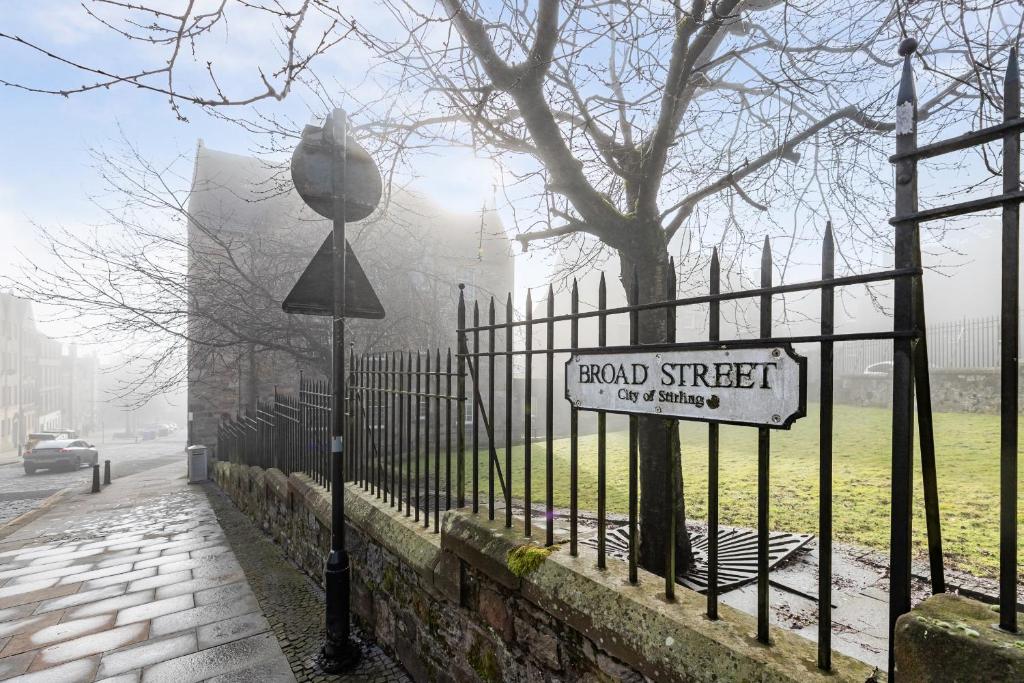 a fence with a road street sign on it at Mar Apartment in Stirling