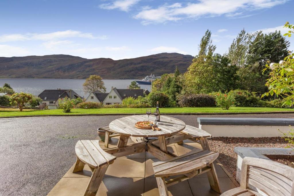 a picnic table with two chairs and a view of a lake at 3 Bed in Ullapool oc-s33063 in Ullapool