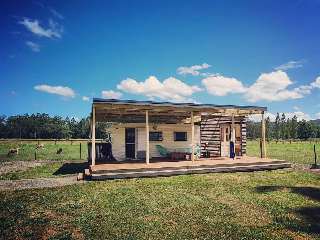 a small house with a roof on a field at Little T in Yarra Junction