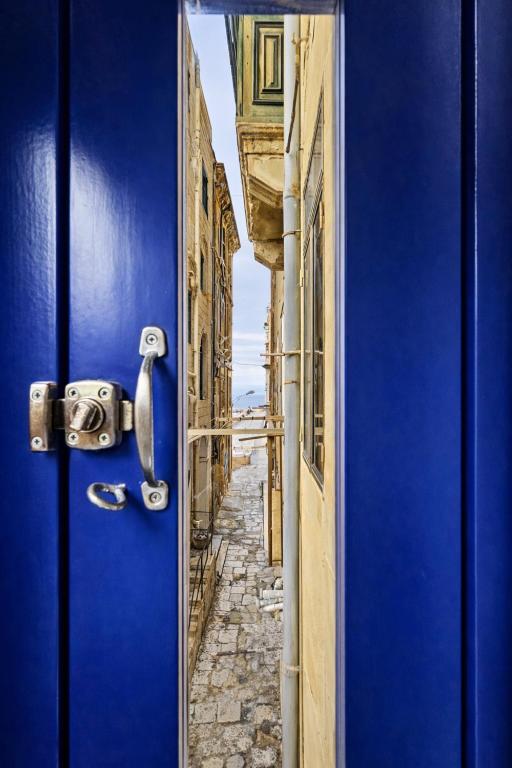 a blue door with a view of a street at The Opal - V3 in Valletta
