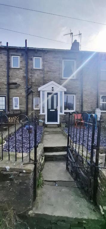 a house with a white door and a fence at Lancaster Cottage in Hawes