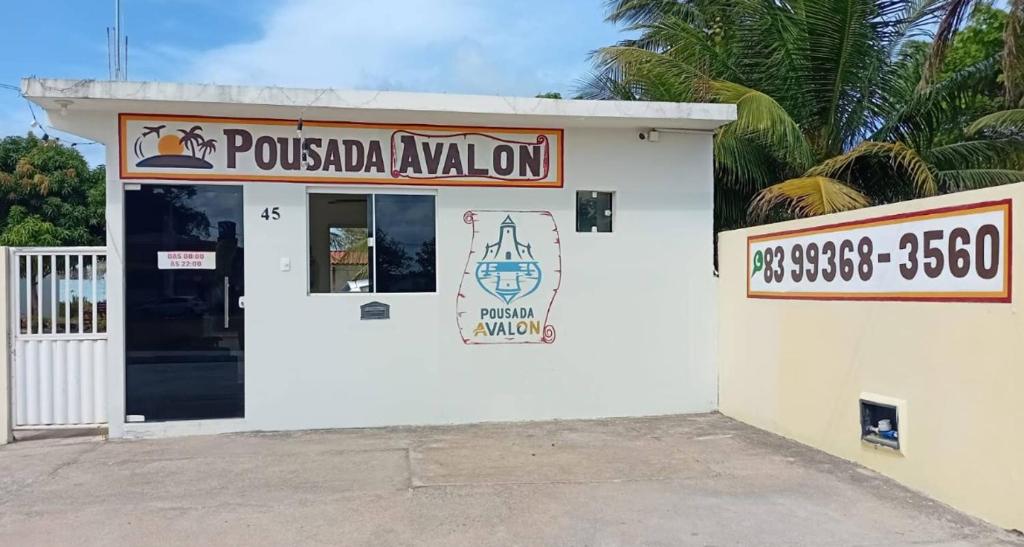 a small white building with a sign on it at Pousada Avalon - Lucena - PB in Lucena