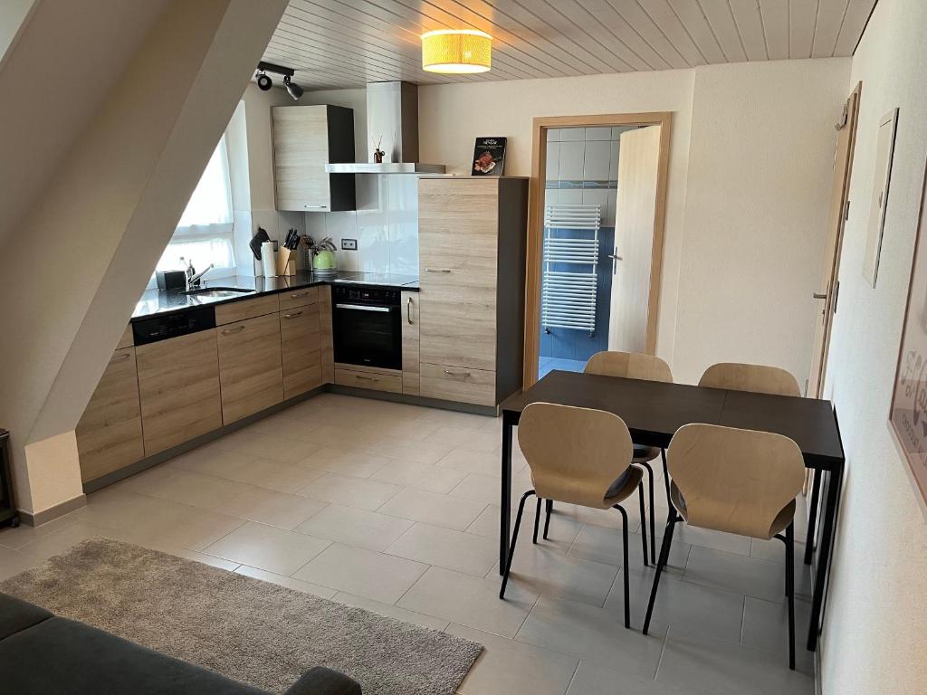a kitchen and dining room with a table and chairs at Cozy appartement de vacances "La Poste" in Saignelégier