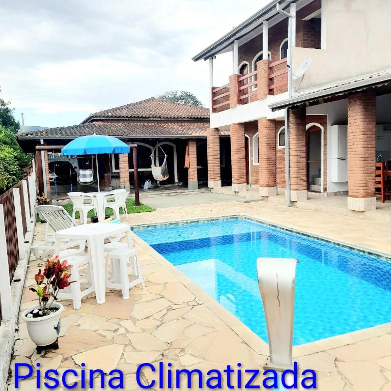a villa with a swimming pool and a house at Chácara Vicente Gazzi in Socorro