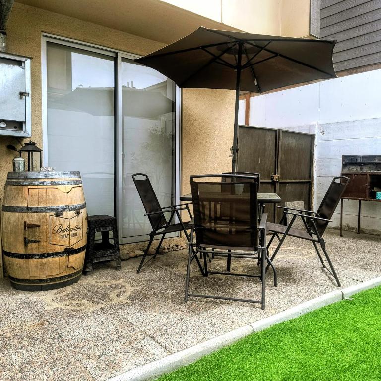 a patio with a table and chairs and an umbrella at CHEZ GERARDo ! in La Serena