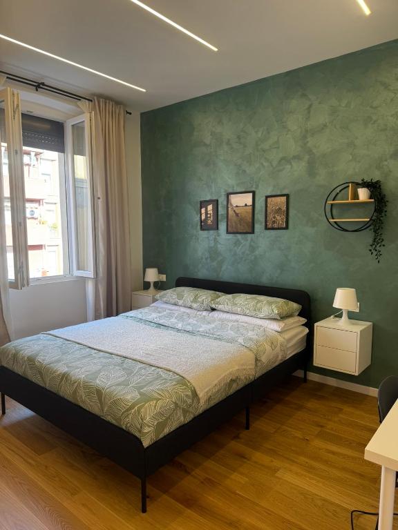 a bedroom with a bed and a green wall at Stay & Solution Apartment in Trieste