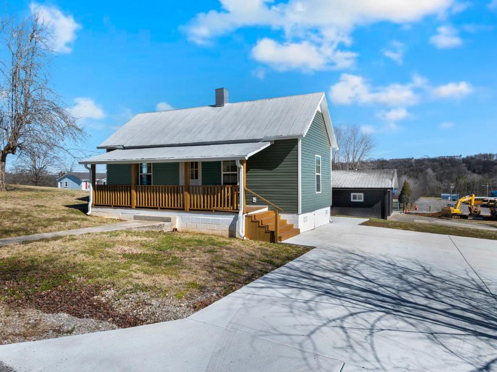 a green house with a porch and a driveway at Lounges at Lynchburg in Lynchburg