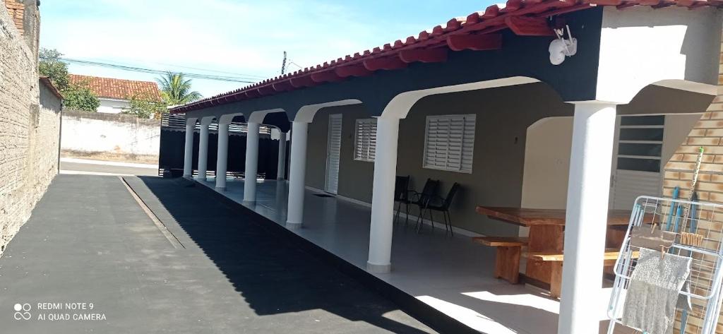 a blue and white building with a bench on a sidewalk at Recanto do Araguaia in Aragarças