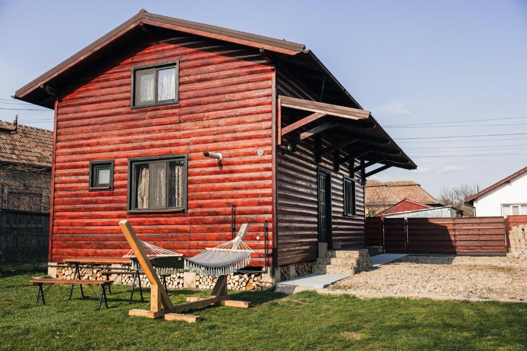 a wooden house with a hammock in front of it at Zen Home in Mihai Viteazu
