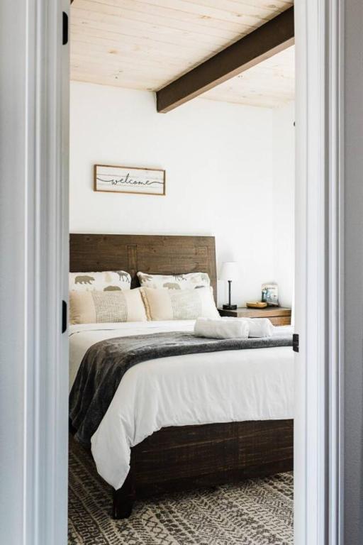 a bedroom with a large bed with a wooden headboard at Little Chip Lake Arrowhead Cabin in Lake Arrowhead