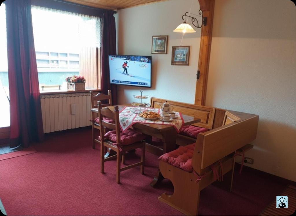 a living room with a dining room table and a television at Soldanella Cervinia apartment Vda Vacanze in Vetta CIR 0253 in Breuil-Cervinia