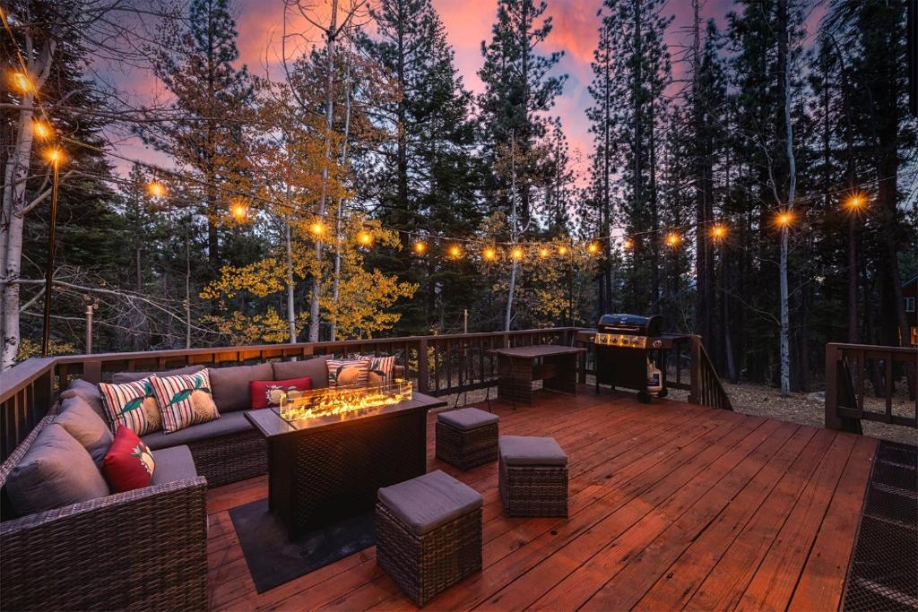 a deck with a couch and a table and lights at River Rock House-Deck-BBQ-Forest Trails & Views! in South Lake Tahoe