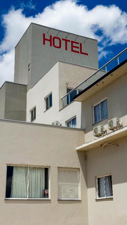 a hotel with a sign on top of a building at Hotel Essência Campo Erê in Campo Erê