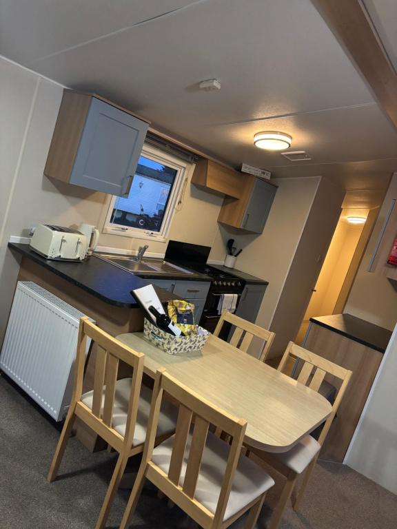 a kitchen and dining room with a table and chairs at Moonstone Costal Caravan Retreat in Saint Margaretʼs at Cliffe