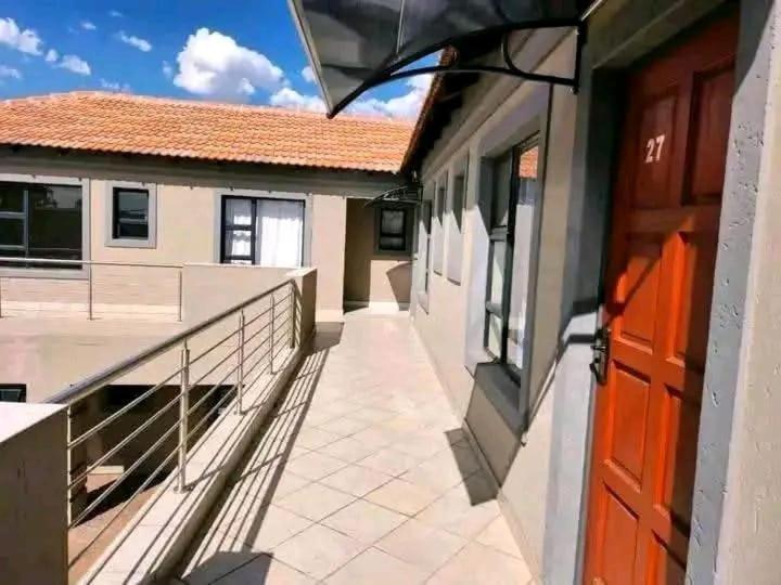 a balcony of a building with a red door at Ben's Place in Pretoria