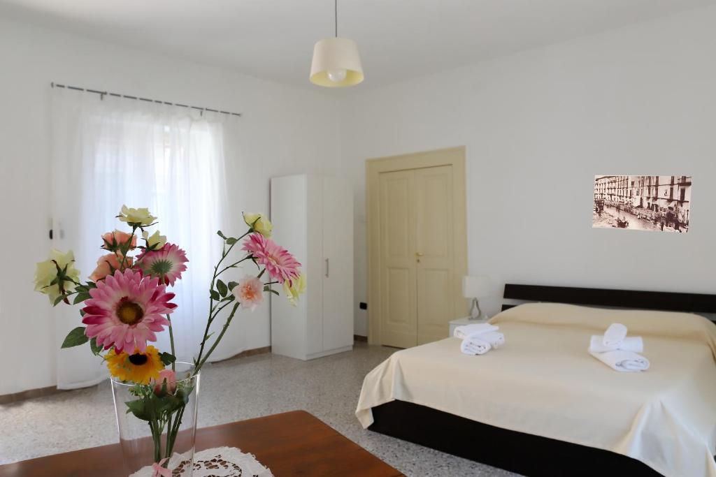 a bedroom with a bed and a vase of flowers on a table at Gragnano in in Gragnano