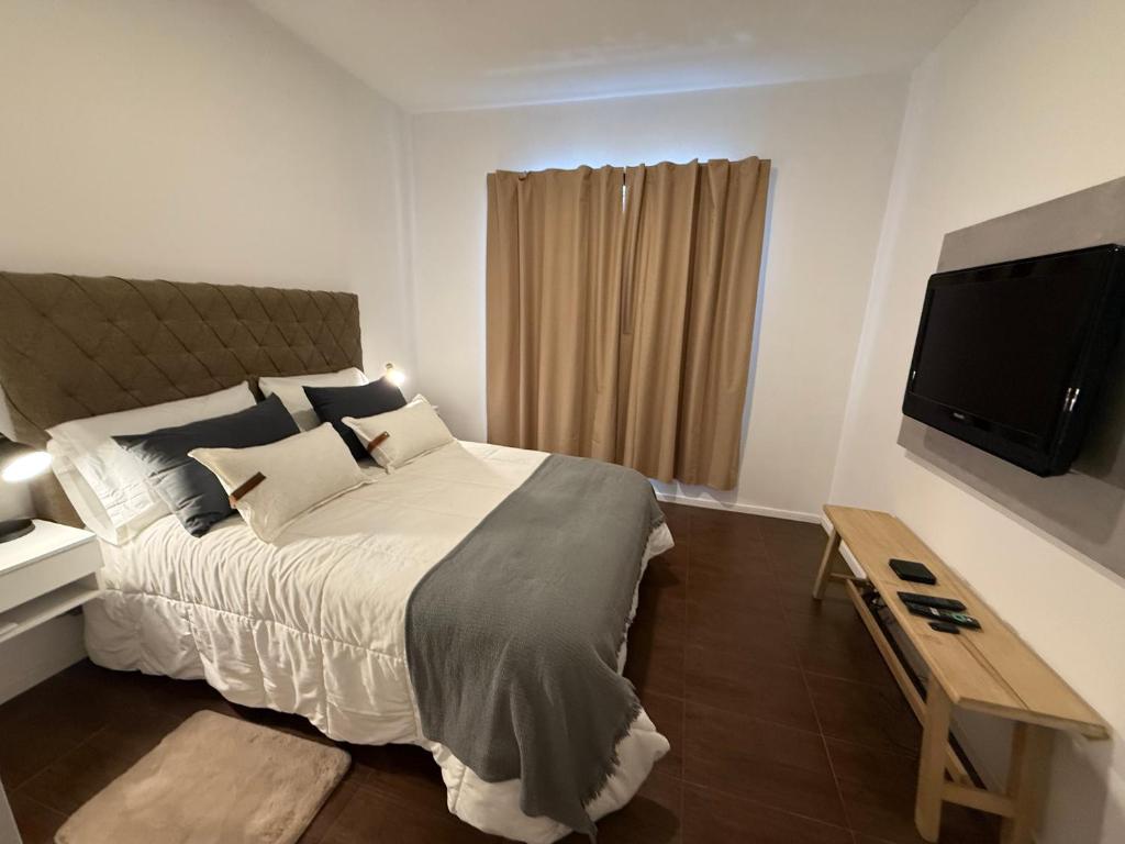 a bedroom with a bed and a flat screen tv at Work & Stay Zarate in Zárate