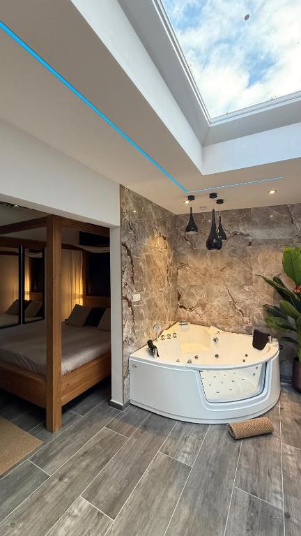 a bath tub in a room with a bedroom at Charnel - Suite Bali in Liège