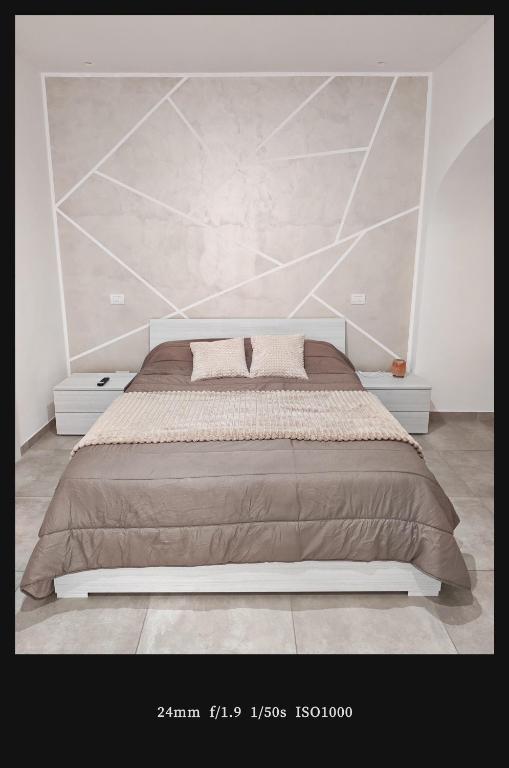 a bedroom with a large bed with a large headboard at MIA GUEST ROOM in Triggiano