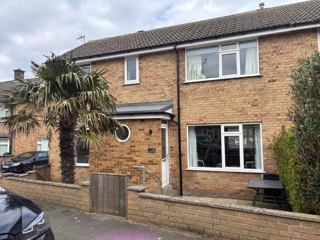 a brick house with a palm tree in front of it at Palm Tree House in Filey