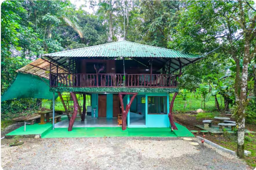 a house with a green roof and a deck at Sloth House Rio Celeste in Rio Celeste