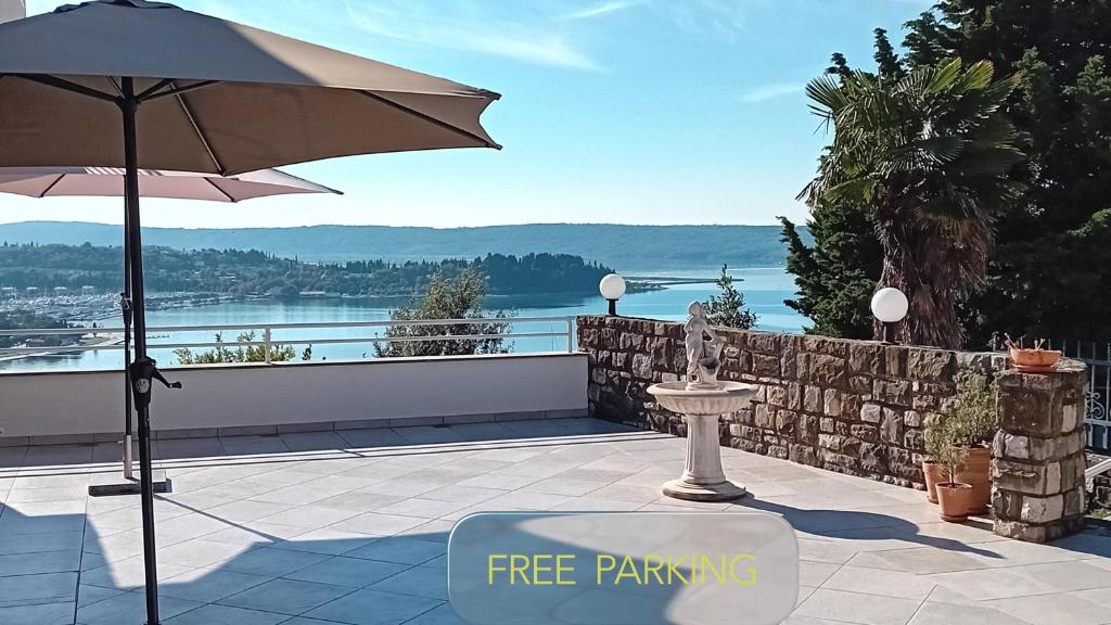 a patio with an umbrella and a view of the water at Apartments Heidi in Portorož